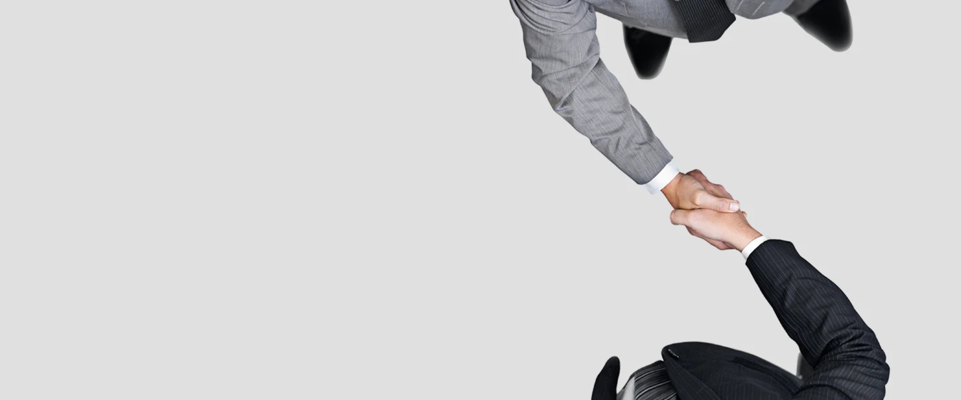 Overhead view of two business professionals in suits shaking hands.