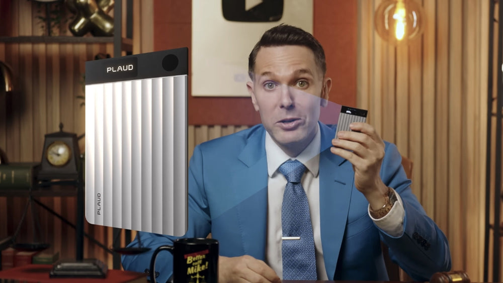 Man in a blue suit holding a silver Plaud Note Pro with a large product overlay.