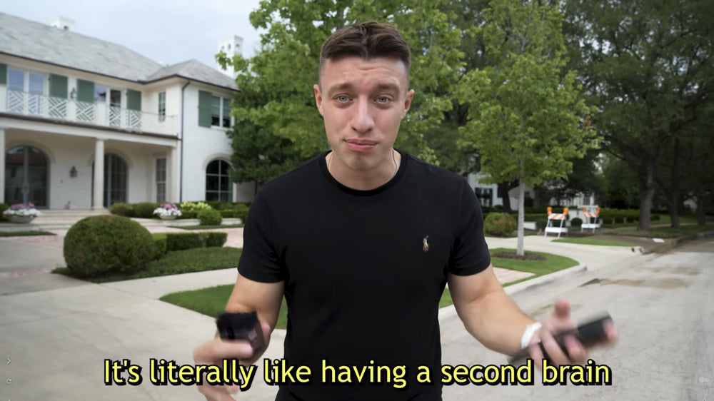 Man holding two black Plaud Note recorders with text: It's literally like having a second brain.