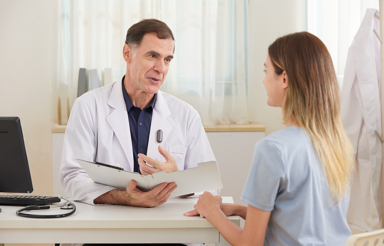 Doctor wearing a black Plaud NotePin on his lab coat during a patient consultation.