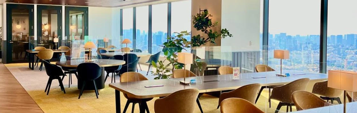 Plaud Note devices on tables in a modern office with large windows and a city skyline view.
